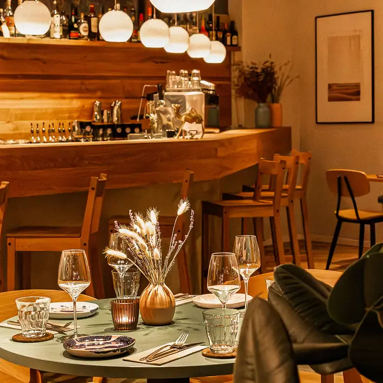 Interieur mit Holzverkleidung und eingedeckten Tischen im Restaurant Nomad in Berlin.