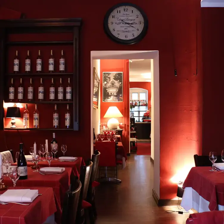 Rot gestalteter Innenraum mit eingedeckten Tischen und Weinregal im Restaurant Patrice, einem der romantischsten Restaurants in Berlin.