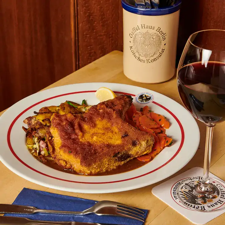 Paniertes Schnitzel und Wein im Gaffel Haus Berlin an der Friedrichstraße.