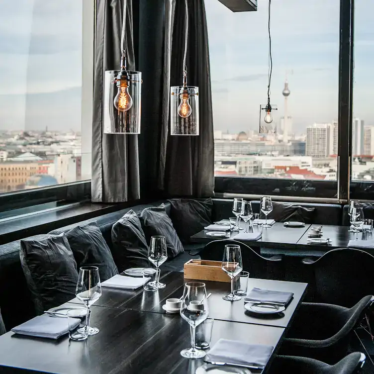 Bequeme Sitzecke mit gemütlicher Couch und traumhafter Aussicht auf den Fernsehturm im Solar, einer der besten Restaurants mit Dachterrasse in Berlin.