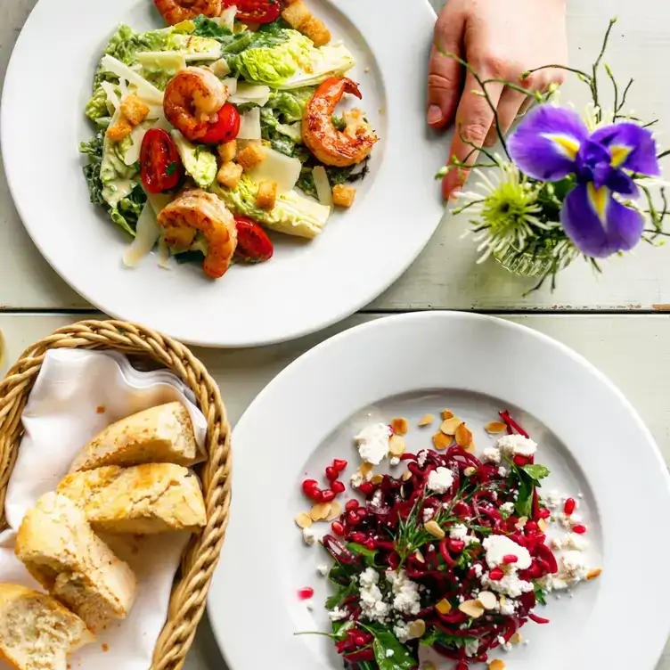 Teller mit fruchtigem Salat und Scampi-Gericht zu Baguette im Katerschmaus, einem der besten Restaurants mit Außenplätzen in Berlin.