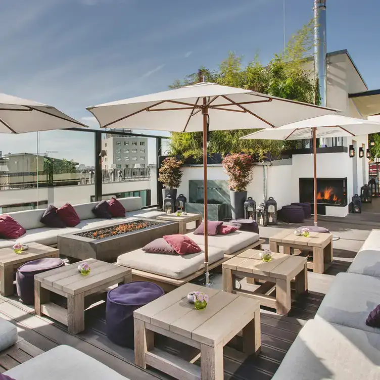 Gemütliche Dachterrasse in der GRACE Bar in Berlin, mit Holzboden und Lounge-Möbeln.