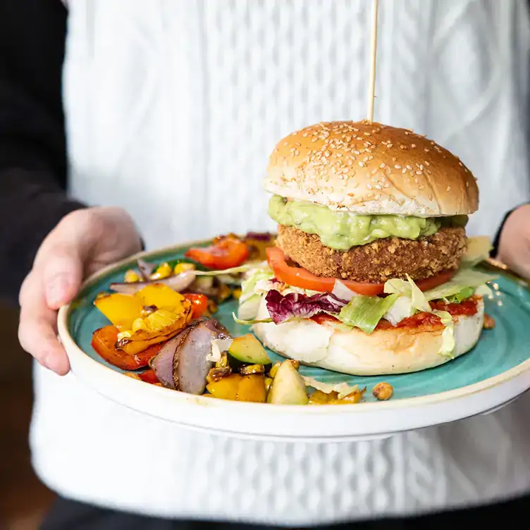 Eine Kellnerin hält einen Burger im SAUSALITOS.