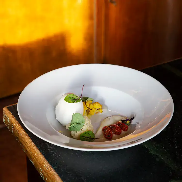 Teller mit edler Burrata, aromatischer Sauce und Gemüse im Briefmarken Weine, einem der besten Restaurants mit Außenbereich in Berlin.