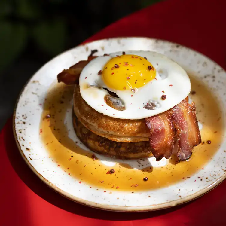 Dicker amerikanischer Pfannkuchen mit Speck und Spiegelei im Spindler, einem der besten Restaurants mit Außenplätzen in Berlin.