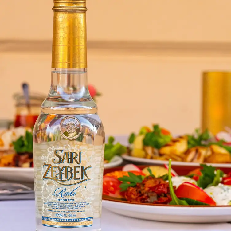 Raki-Flasche mit verschiedenen kleinen Häppchen im Hintergrund bei ZaZa Meze Bar, einem der besten türkischen Restaurants in München