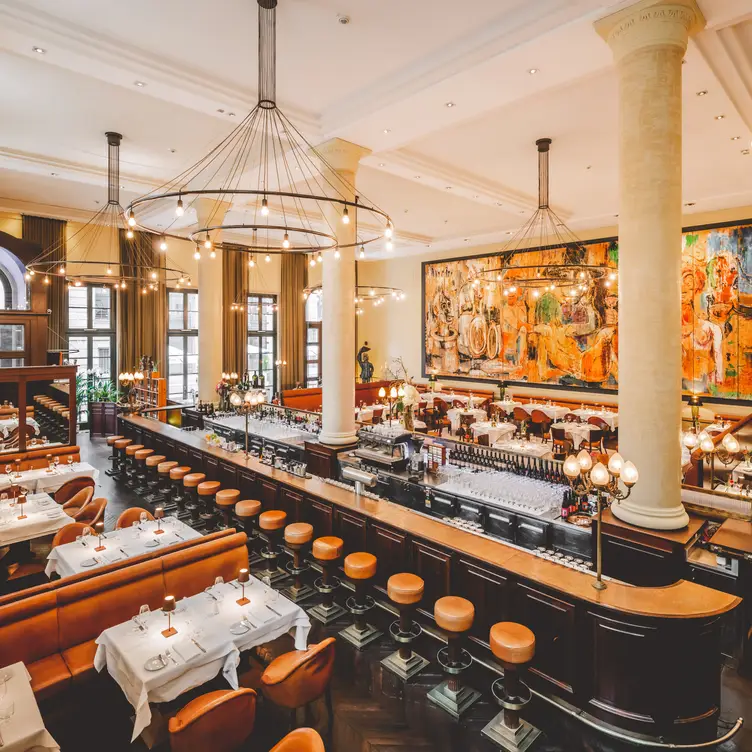 Prunkvoller Speisesaal mit Theke in der Mitte und großflächigem Kunstwerk im französischen Hauptstadtrestaurant Gendarmerie in Berlin