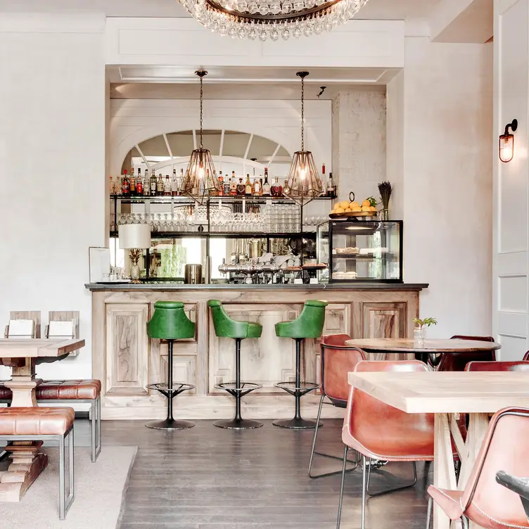 Helles Design mit stilvoller Theke und eleganten Leuchtern im SPINDLER, einem der besten französischen Restaurants in Berlin