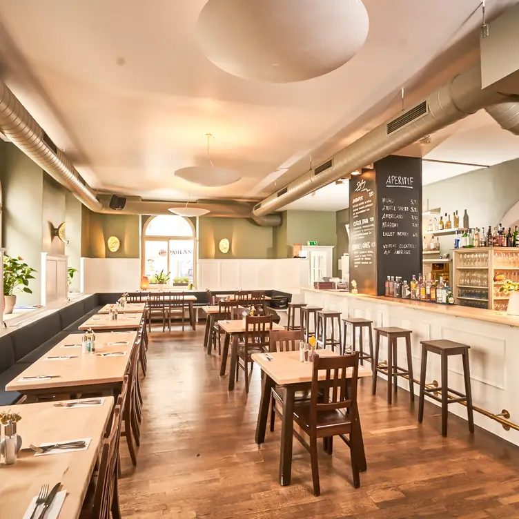 Heller Gastraum mit freundlichem Anstrich und eleganten Holztischen in der Dilan MezeBar, einem der besten türkischen Restaurants in München.