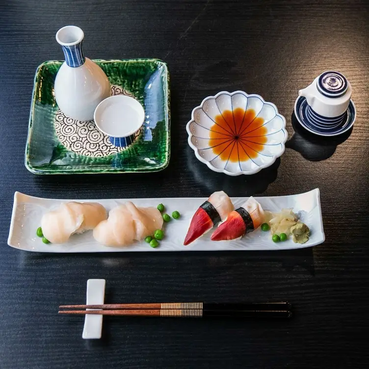 Nigiri und Sashimi mit Sojasauce und Sake im YOSHI im Alsterhaus, einem der besten Sushi-Restaurants in Hamburg, serviert.