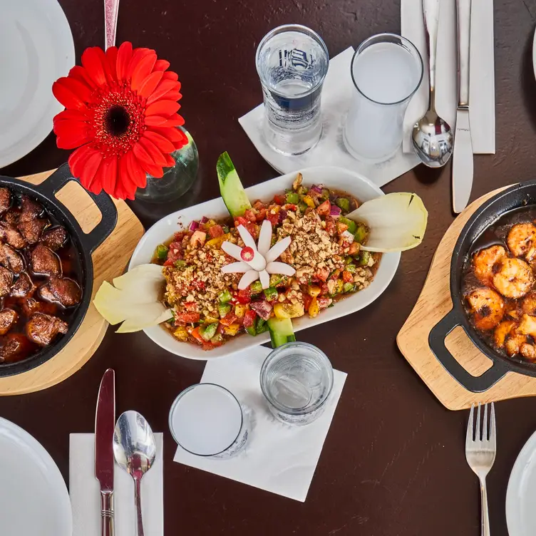 Tisch mit zwei Schmorgerichten und herzhaftem Salat im Merhaba Restaurant, einem der besten türkischen Restaurants in München.