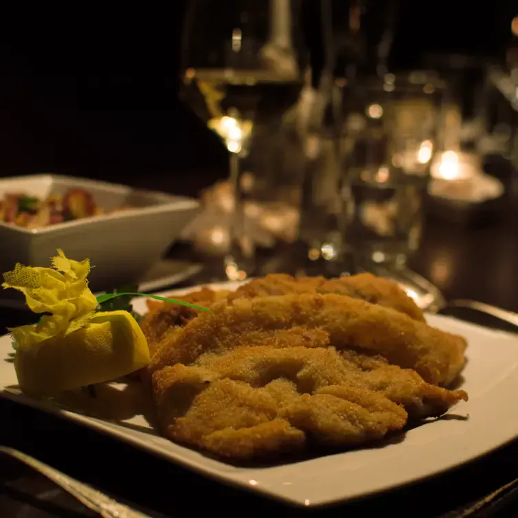 Kross gebratenes Wiener Schnitzel mit Zitrone, serviert im Das Dorf in Hamburg.