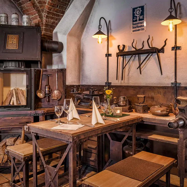 Mittelalterliches Ambiente mit Holz und Kamin in einem der Stüberl des Garchinger Augustiner, einem der besten bayerischen Restaurants in München.