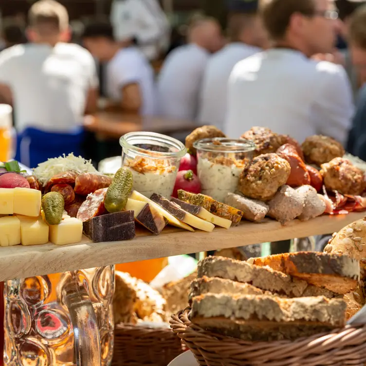 Krustiges Bauernbrot mit Käse, Wurst, Gürkchen und Aufstrich zur Brotzeit im Paulaner am Nockherberg, einem der besten bayerischen Restaurants in München.