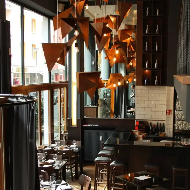 Das Interieur der Henne Weinbar mit schön designten Lampen und einer Bar mit Stühlen macht es zu einem der beliebtesten romantischen Restaurants in Köln.