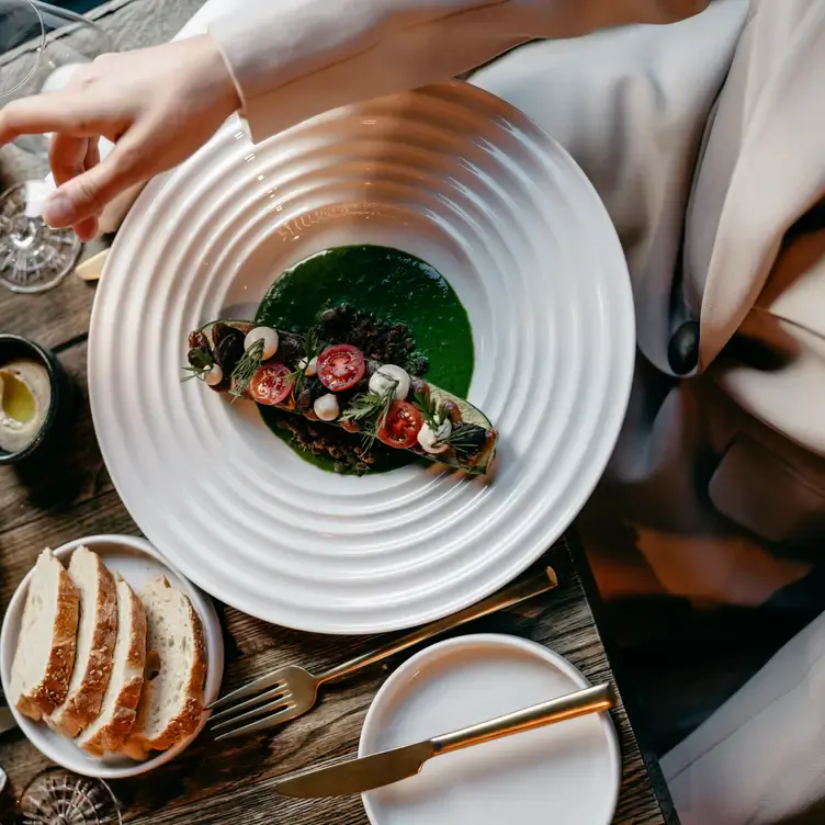 Vorspeise mit grüner Sauce, Tomaten, Mozzarella und Weißbrot im Restaurant 10012 in Frankfurt.