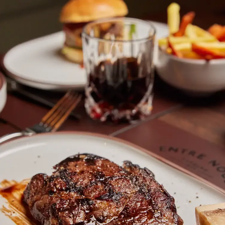 Kross gegrilltes Steak und Burger im Hintergrund im Entre nous – Beisser Hamburg 1836, einem der besten romantischen Restaurants in Hamburg.