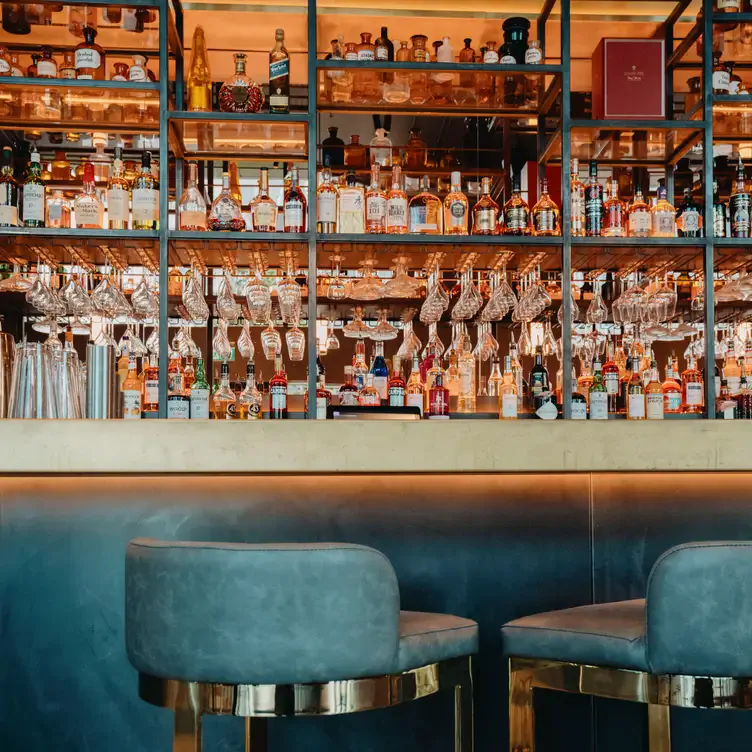 Barbereich mit Cocktailgläsern und samtenen Hockern im The Alchemist, einem der besten neuen Restaurants in Berlin 2024.