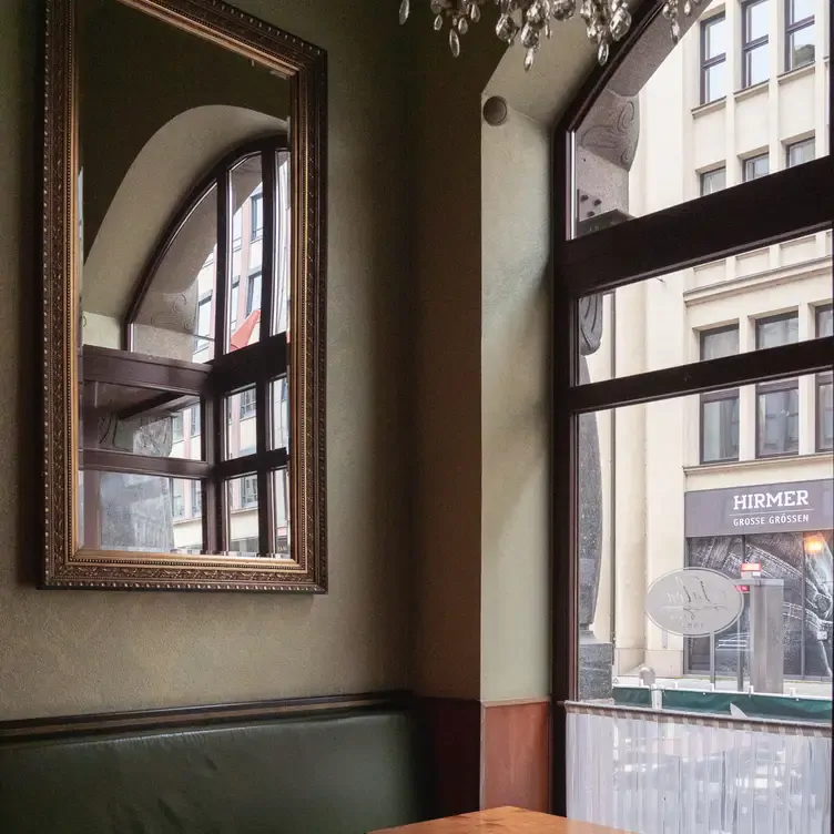 Gemütliche Sitzecke mit Spiegel im französischen Stil bei Café Paris, einem Restaurant mit dem besten Brunch in Hamburg.