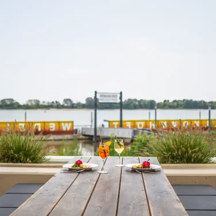 Blick auf die Elbe und dekorierter Tisch im Hamburger Biergarten Das NEUE Schulauer Fährhaus.