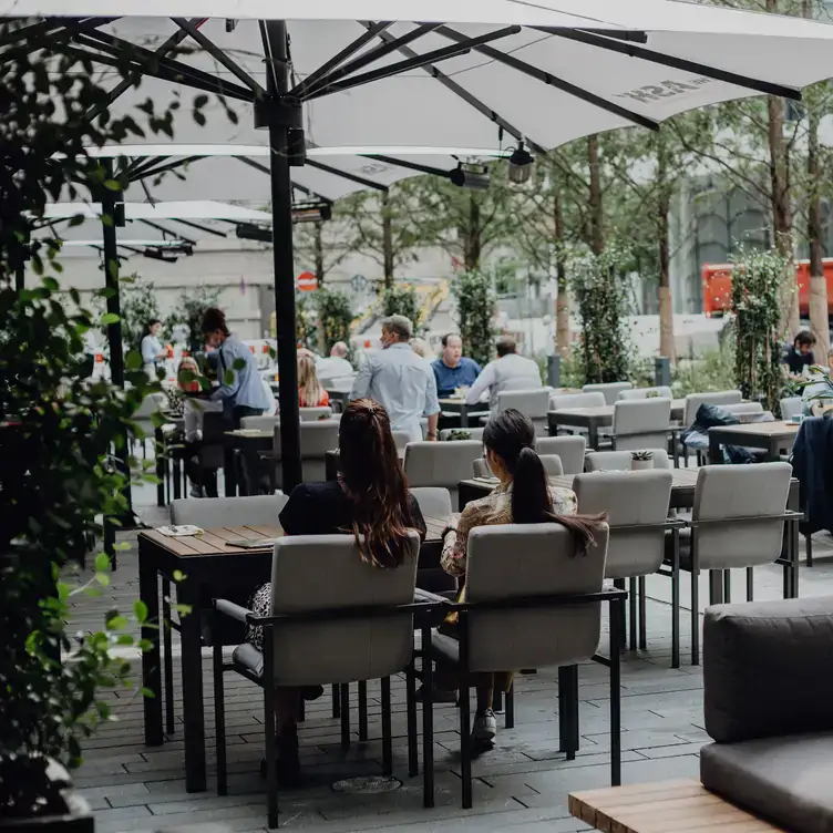 In grauen Tönen gestaltete Terrasse mit gemütlichen Sitzen im Frankfurter Biergarten ASH mit Terrasse.