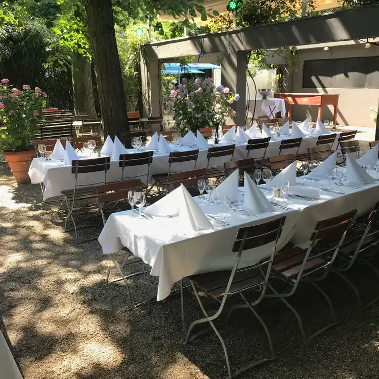 Gedeckte Tische im Biergarten des Stadtgarten Restaurant, einem der beliebtesten Biergärten in Köln.