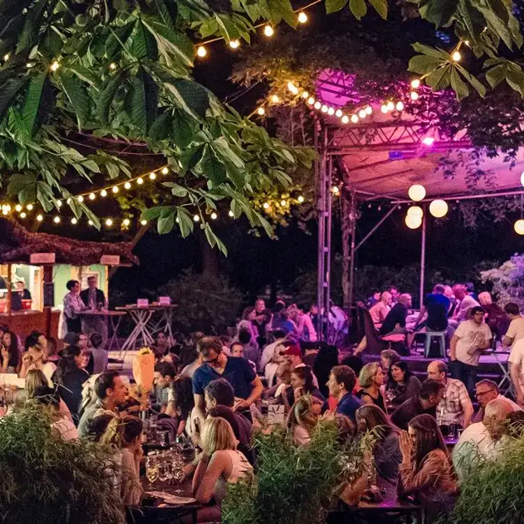 Außenbereich des Kölner Biergartens Stadtgarten Restaurant bei Nacht und mit Beleuchtung.