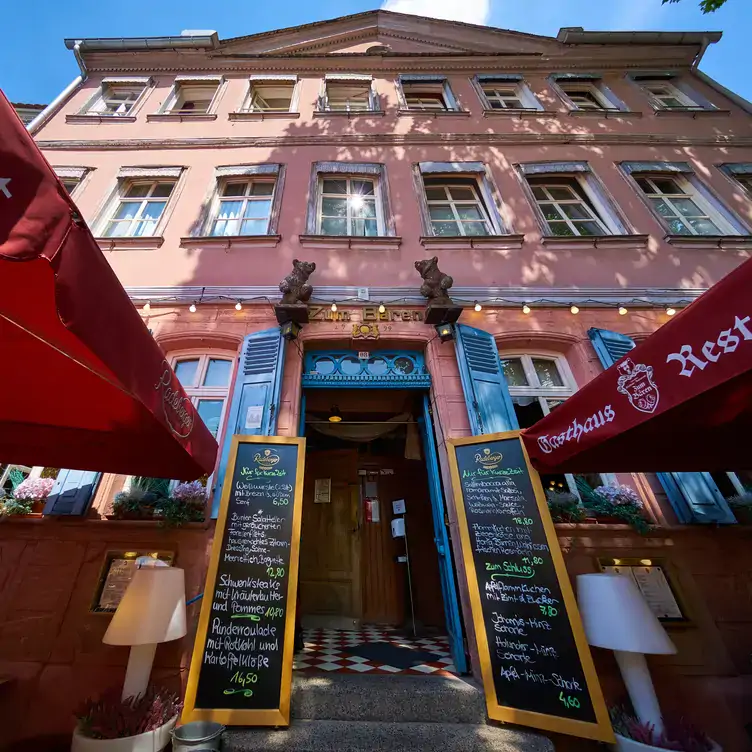 Eingang mit Speisekarte und Schirmen im Gasthaus zum Bären in Frankfurt.