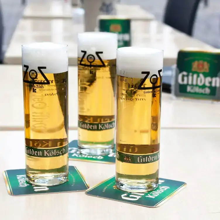 Drei Gläser Kölsch auf einem Tisch im Gilden im Zims, einem der schönsten Biergärten in Köln.