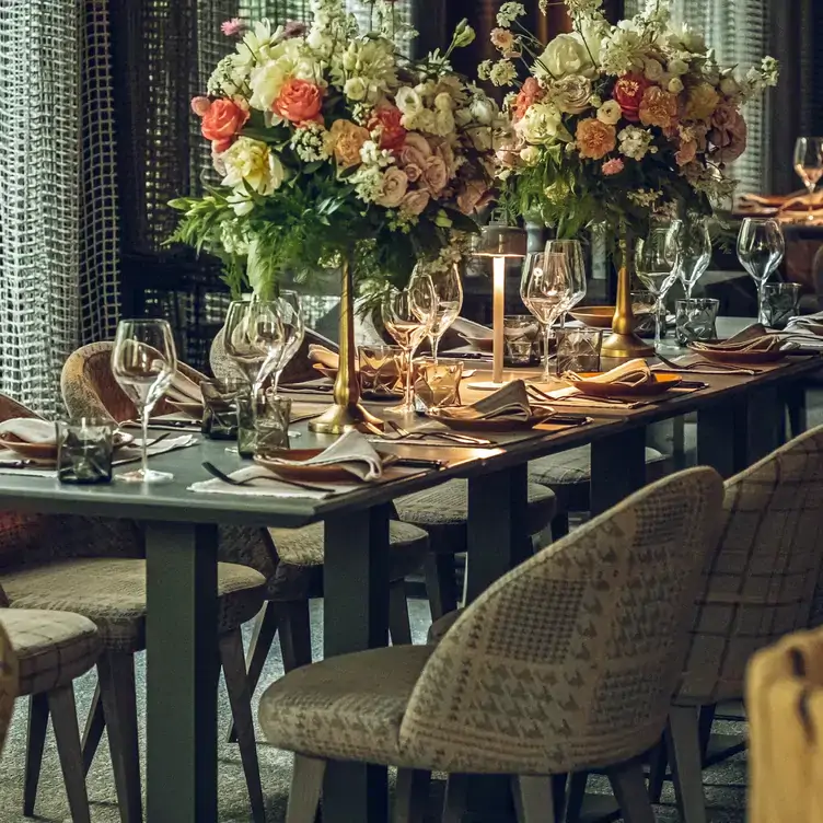 Gedeckte Tafel mit Blumensträußen beim Italiener Via Monte Napoleone, einem der besten Restaurants für Gruppen in Frankfurt.