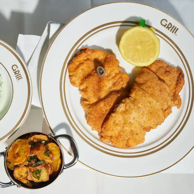 Wiener Schnitzel mit Zitrone und einer Schale Bratkartoffeln im GRILL, einem der besten Restaurants.