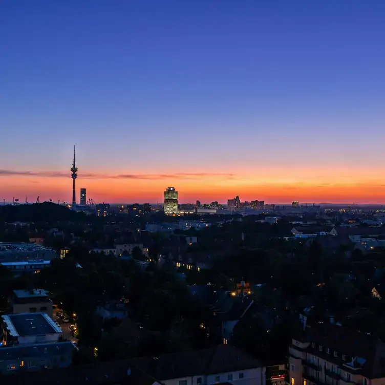 Sensationeller Sonnenuntergang über der Stadt München von der M'uniqo Rooftop Bar aus, einem der besten Restaurants mit Blick in München.