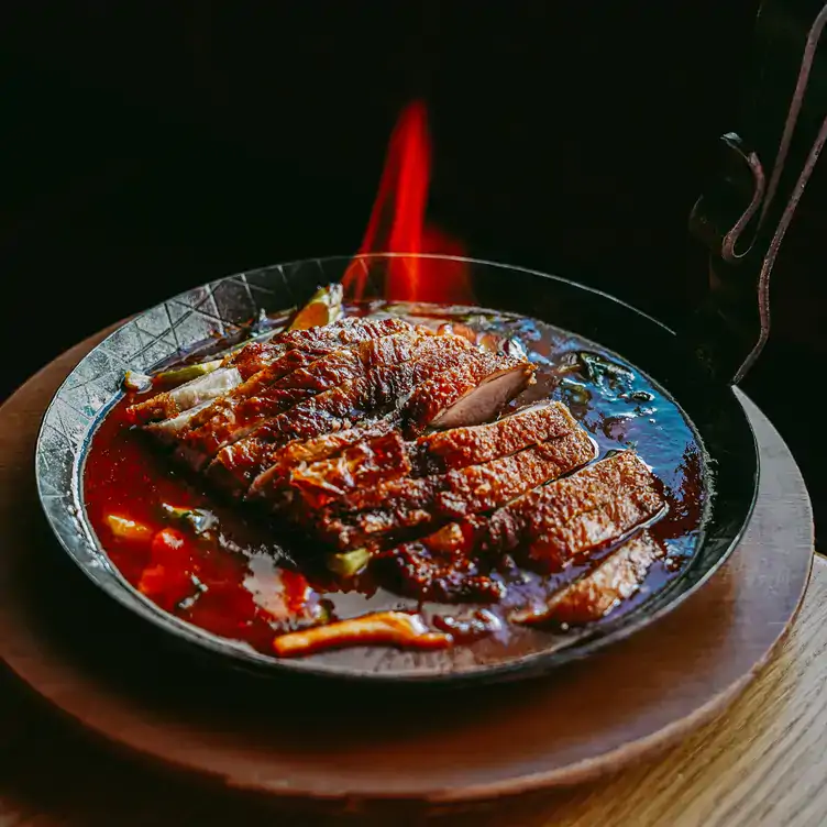 Flambierte Ente in würziger Hoisin Soße in heißer Pfanne serviert im Jaadin Grillhaus.