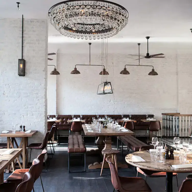 Blick ins Restaurant SPINDLER mit modernem Interieur und weißen Backsteinwänden.